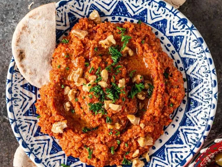 Muhammara dip garnished with herbs