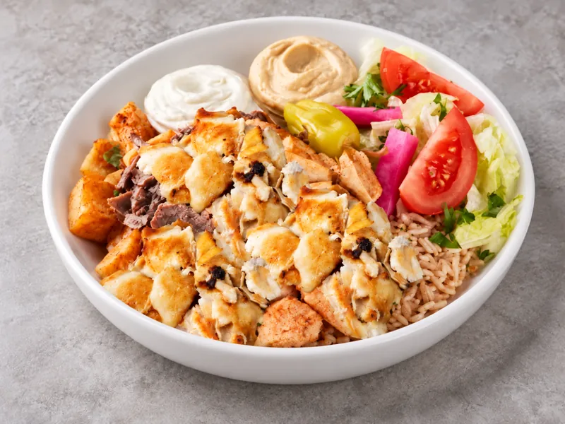 Chicken shawarma bowl with rice, vegetables and dips