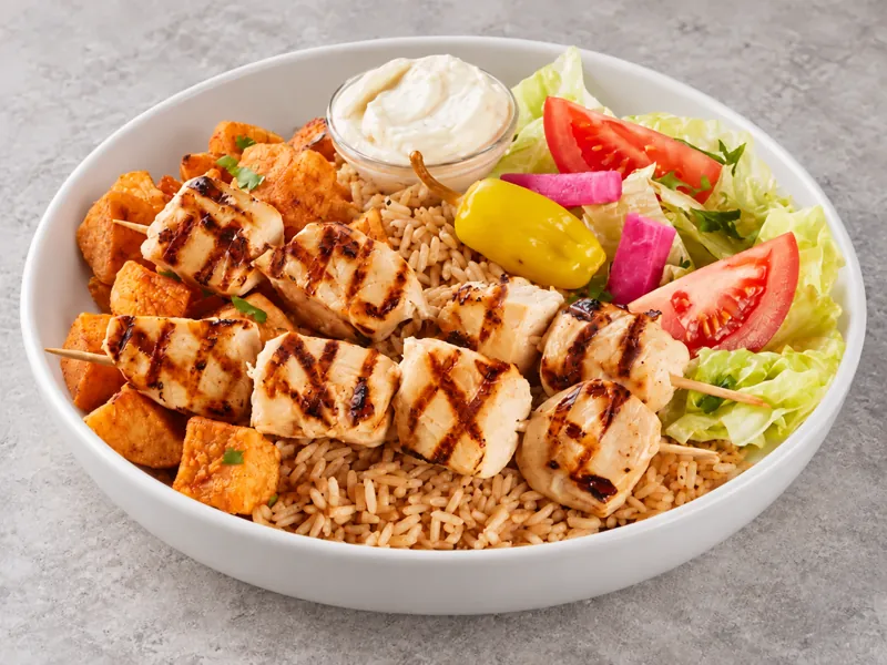 Chicken skewer bowl with rice, vegetables and dips
